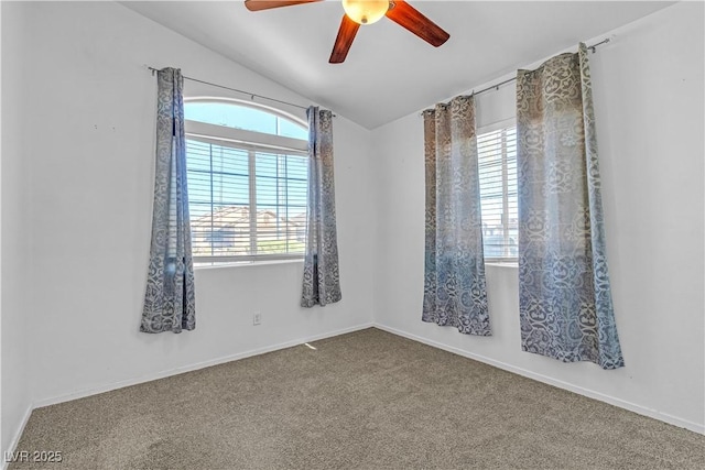 carpeted empty room featuring vaulted ceiling, a ceiling fan, and baseboards
