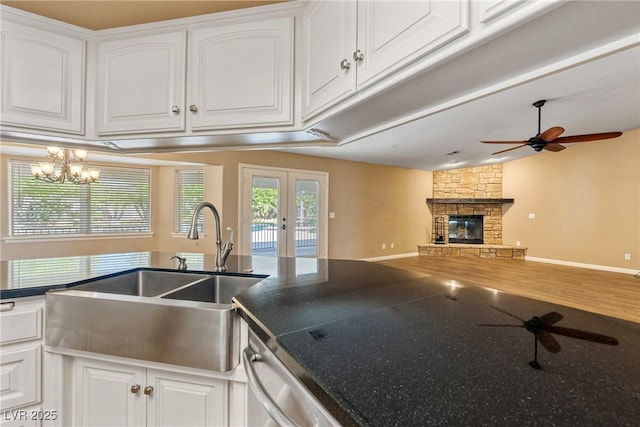 2681 Underbrush Ave, Pahrump, NV 89048 - kitchen with white cabinets, ceiling fan with notable chandelier, french doors, and a sink