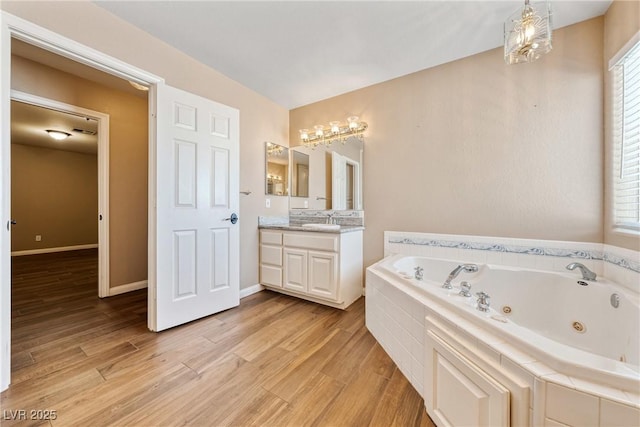 2681 Underbrush Ave, Pahrump, NV 89048 - bathroom featuring baseboards, wood finished floors, vanity, and a whirlpool tub