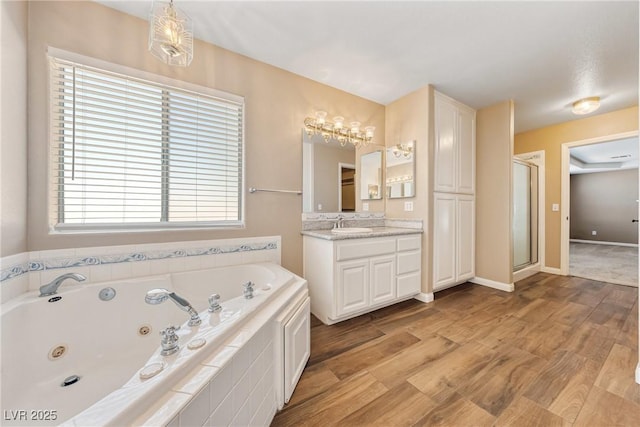 2681 Underbrush Ave, Pahrump, NV 89048 - bathroom featuring wood finished floors, vanity, a shower stall, and a tub with jets