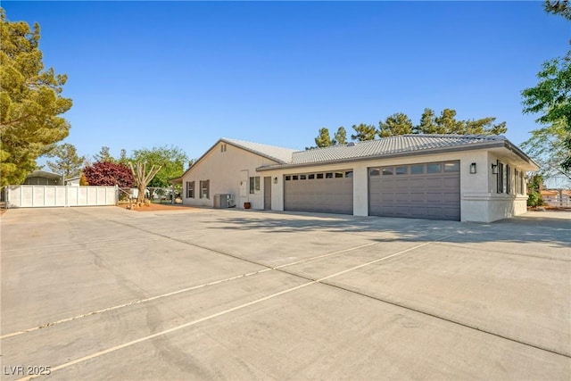 2681 Underbrush Ave, Pahrump, NV 89048 - view of property exterior with fence, a tiled roof, stucco siding, an attached garage, and driveway