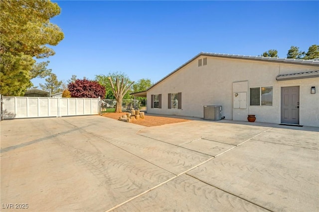 2681 Underbrush Ave, Pahrump, NV 89048 - back of property with a gate, fence, cooling unit, stucco siding, and a patio area
