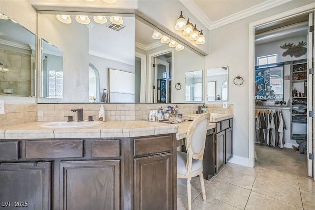 8537 Eureka Heights Ct, Las Vegas, NV 89178 - full bath with tasteful backsplash, double vanity, crown molding, tile patterned flooring, and a spacious closet