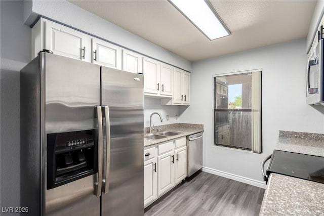 2451 N Rainbow Blvd Unit 1016, Las Vegas, NV 89108 - kitchen featuring stainless steel appliances, white cabinetry, wood finished floors, and light countertops