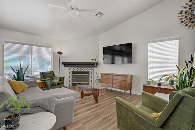 1830 Ginger Blossom Ave, North Las Vegas, NV 89031 - living room with light wood-style floors, a fireplace, ceiling fan, and baseboards
