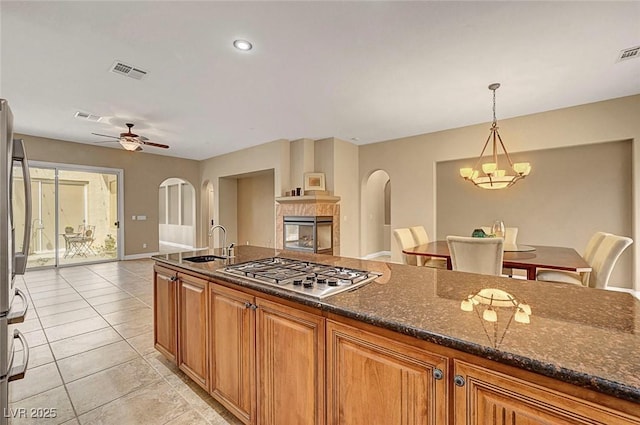 519 Via Garofano Ave, Henderson, NV 89011 - kitchen featuring a sink, appliances with stainless steel finishes, a chandelier, a ceiling fan, and dark stone counters