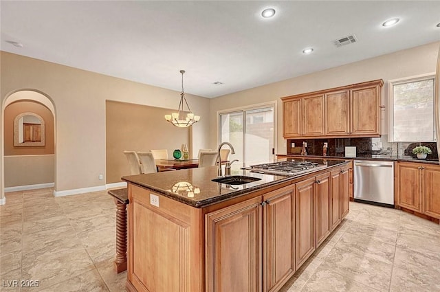 519 Via Garofano Ave, Henderson, NV 89011 - kitchen featuring appliances with stainless steel finishes, a sink, an island with sink, baseboards, and dark stone countertops
