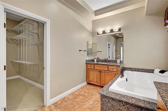 519 Via Garofano Ave, Henderson, NV 89011 - bathroom featuring vanity, a garden tub, a spacious closet, and baseboards