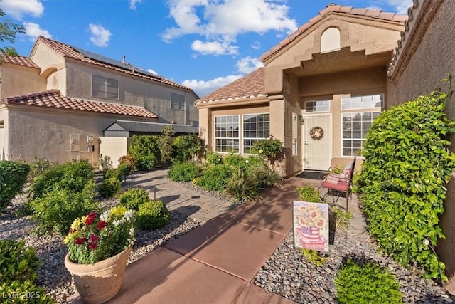 property entrance featuring a tiled roof and stucco siding