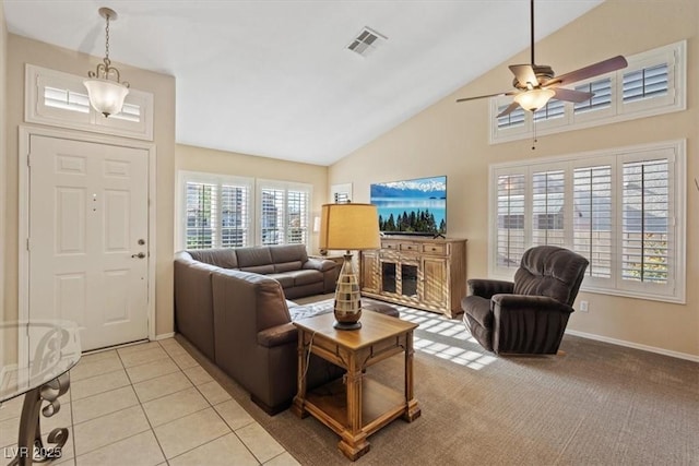 living area with baseboards, light tile patterned floors, visible vents, ceiling fan, and high vaulted ceiling