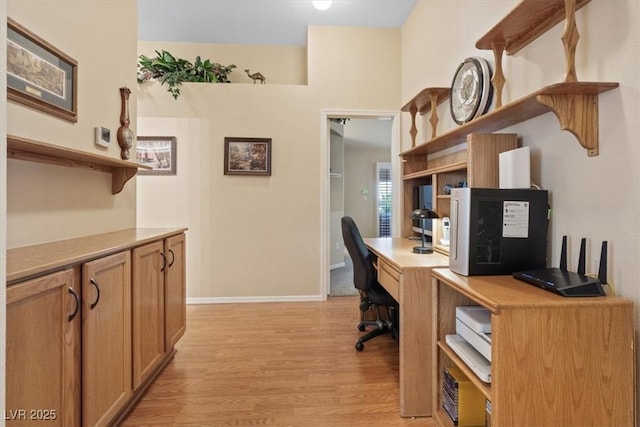 office space with baseboards and light wood-style floors