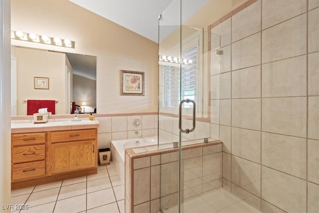 bathroom with vanity, a stall shower, tile patterned flooring, tile walls, and a garden tub