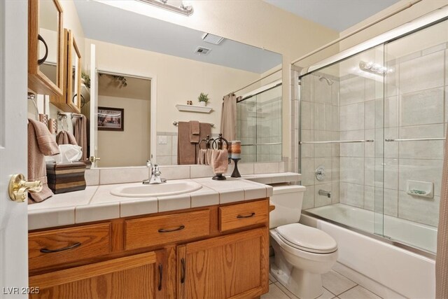 full bathroom with visible vents, combined bath / shower with glass door, toilet, vanity, and tile patterned floors