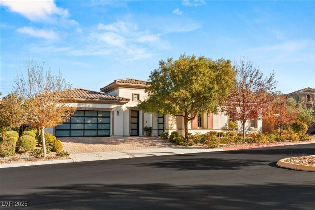 28 Tea Olive Dr, Las Vegas, NV 89141 - view of front of house featuring driveway, a tile roof, a garage, and stucco siding