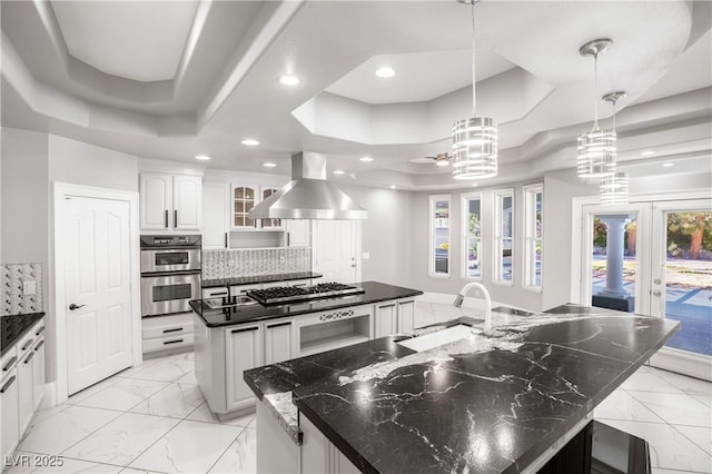 kitchen with ventilation hood, marble finish floor, a large island, and a raised ceiling