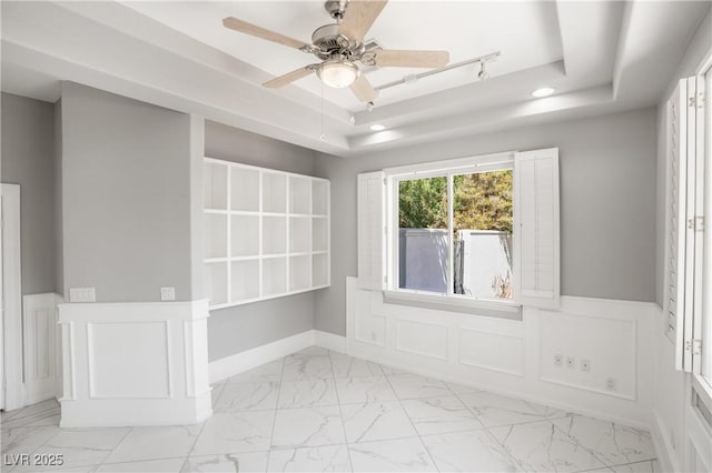 unfurnished room with a ceiling fan, marble finish floor, recessed lighting, and a raised ceiling