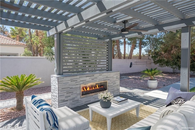 view of patio with a pergola, ceiling fan, fence, and an outdoor living space with a fireplace