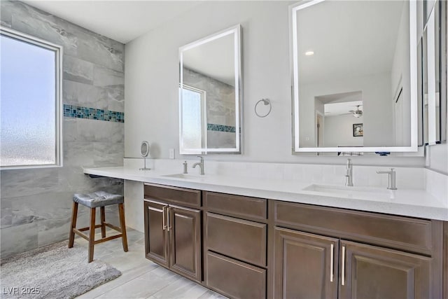 bathroom with double vanity, a sink, and a healthy amount of sunlight