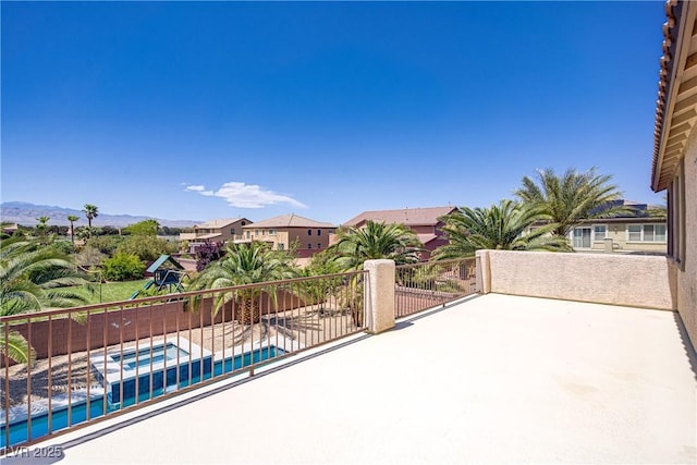 view of patio / terrace featuring a playground, a pool with connected hot tub, and a residential view