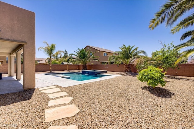 view of swimming pool featuring a fenced backyard, a pool with connected hot tub, and a patio area