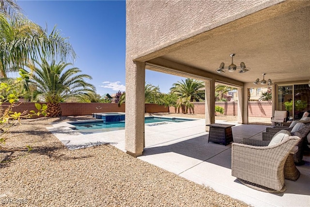 view of swimming pool featuring a patio, a pool with connected hot tub, and a fenced backyard