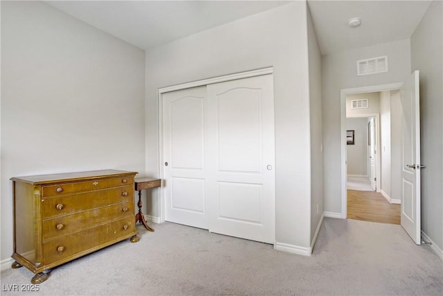 bedroom with carpet floors, baseboards, a closet, and visible vents