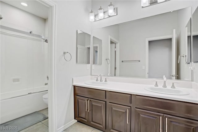 bathroom with tile patterned flooring, a sink, double vanity, and toilet