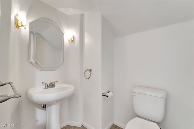 half bath with baseboards and toilet