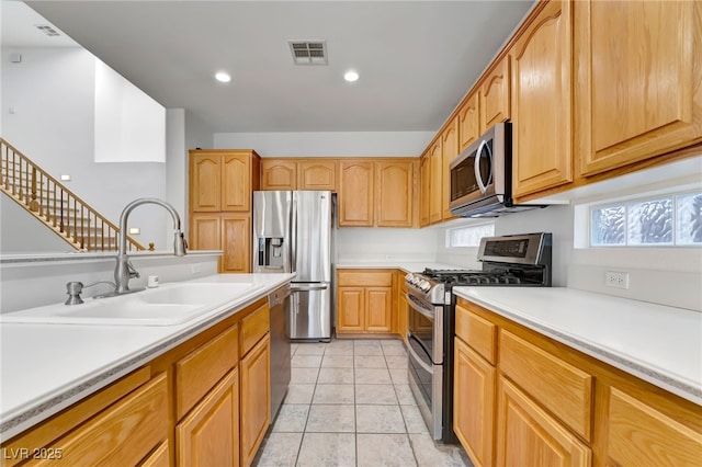 kitchen featuring light countertops, stainless steel appliances, visible vents, and a sink