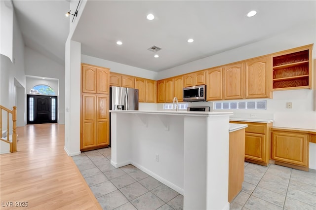 kitchen with recessed lighting, an island with sink, stainless steel appliances, light countertops, and visible vents