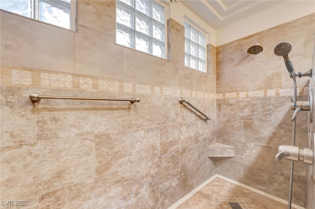 bathroom with tiled shower and a wealth of natural light