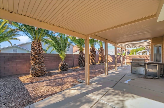 view of patio with area for grilling and a fenced backyard