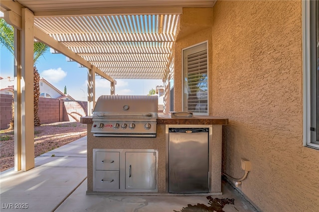 view of patio / terrace with an outdoor kitchen, fence, grilling area, and a pergola