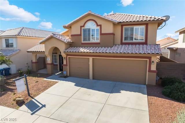 mediterranean / spanish-style home with a garage, a tile roof, stucco siding, and driveway