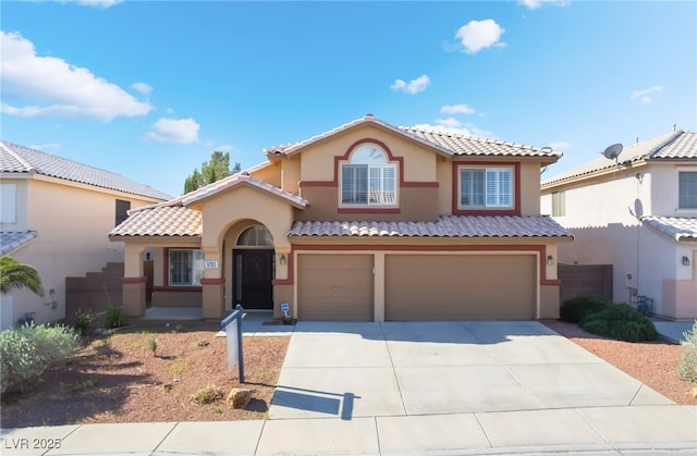 mediterranean / spanish home featuring stucco siding, driveway, an attached garage, and a tile roof