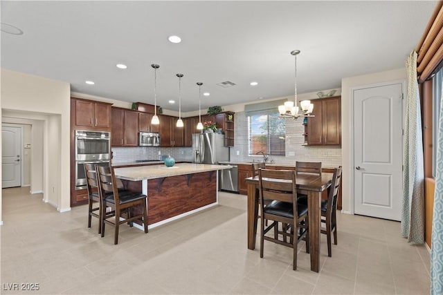 1776 Gentle Brook St, North Las Vegas, NV 89084 - kitchen featuring visible vents, backsplash, a notable chandelier, and stainless steel appliances