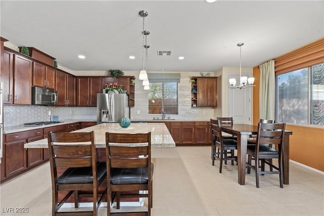 1776 Gentle Brook St, North Las Vegas, NV 89084 - kitchen with tasteful backsplash, visible vents, a chandelier, appliances with stainless steel finishes, and a sink