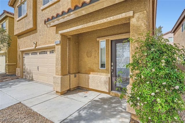 9651 Bouncing Ball St, Las Vegas, NV 89178 - doorway to property featuring a garage, stucco siding, concrete driveway, and a tile roof