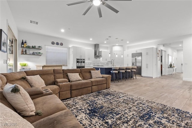 living room featuring recessed lighting, light wood finished floors, visible vents, and a ceiling fan