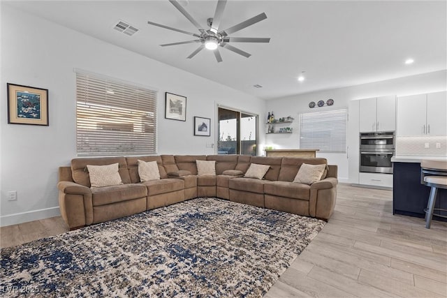 living room with baseboards, recessed lighting, light wood-style floors, visible vents, and ceiling fan