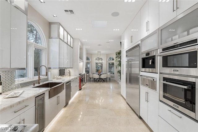 8109 Moonstone Cir, Las Vegas, NV 89128 - kitchen featuring stainless steel appliances, a sink, a warming drawer, and modern cabinets