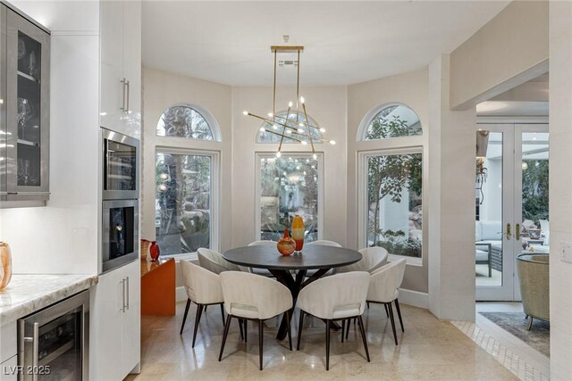 8109 Moonstone Cir, Las Vegas, NV 89128 - dining room with beverage cooler, a wealth of natural light, and an inviting chandelier
