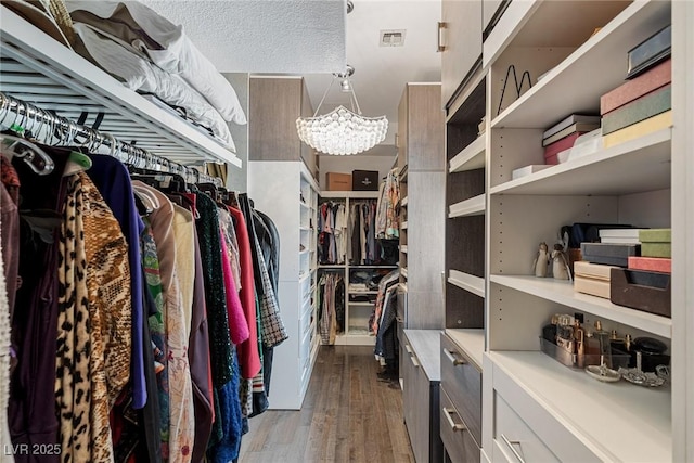 8109 Moonstone Cir, Las Vegas, NV 89128 - walk in closet with visible vents, dark wood-style floors, and a chandelier