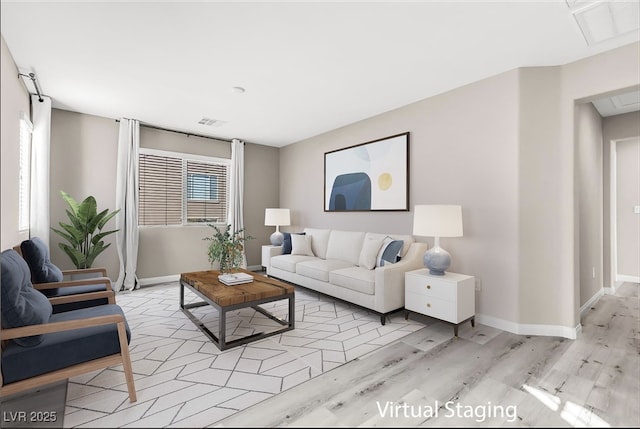 living room featuring light wood-style flooring, visible vents, and baseboards