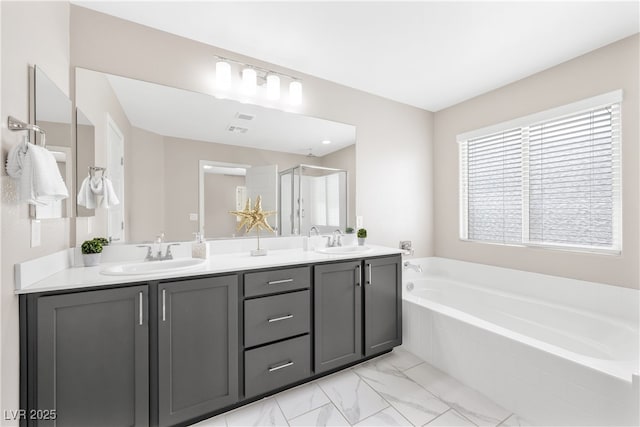 full bathroom with a shower stall, double vanity, a garden tub, and a sink