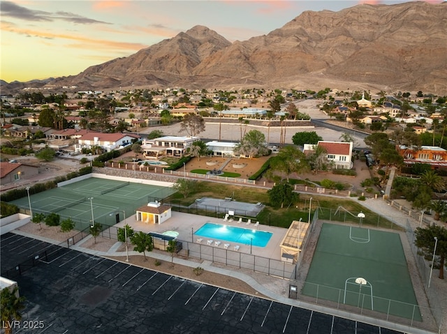 6861 E Washington Ave, Las Vegas, NV 89110 - aerial view at dusk of a mountain view, view of pool, and a residential view