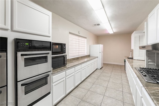 6861 E Washington Ave, Las Vegas, NV 89110 - kitchen with appliances with stainless steel finishes, white cabinets, light tile patterned floors, and light stone countertops