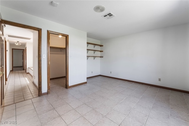 6861 E Washington Ave, Las Vegas, NV 89110 - unfurnished bedroom featuring light tile patterned floors, a spacious closet, baseboards, and a closet