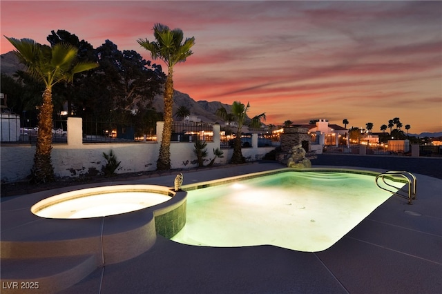 6861 E Washington Ave, Las Vegas, NV 89110 - pool at dusk with a pool with connected hot tub and fence