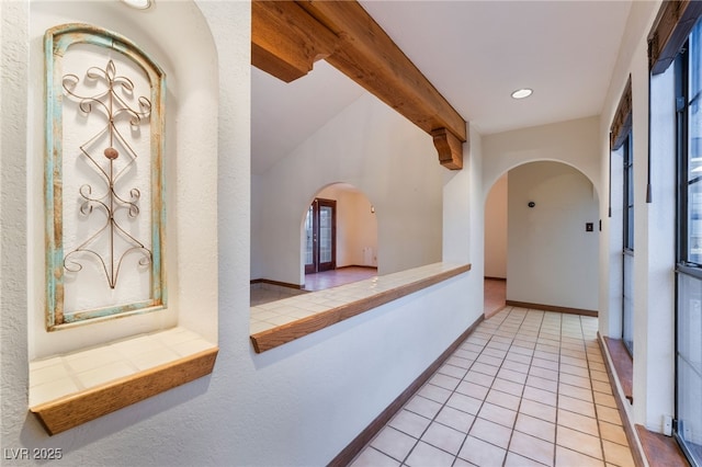 6861 E Washington Ave, Las Vegas, NV 89110 - hallway with arched walkways, light tile patterned floors, beamed ceiling, recessed lighting, and baseboards
